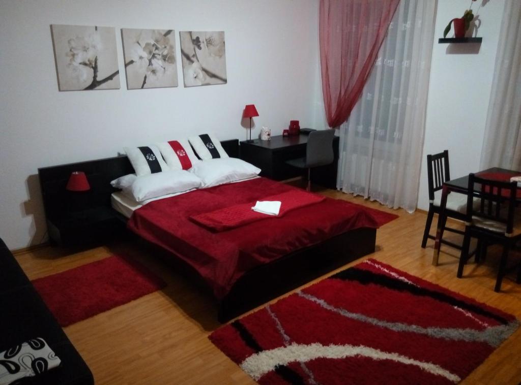 デブレツェンにあるDebreCenter Apartmanのベッドルーム1室(赤い毛布付きのベッド1台付)