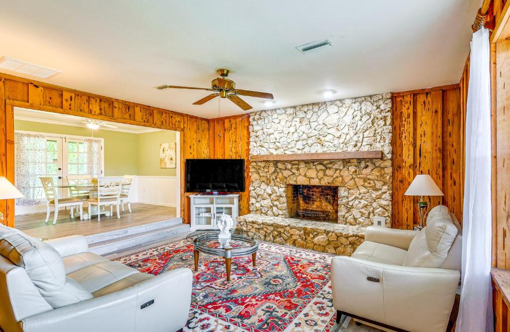 a living room with a stone wall with a fireplace at Less Than 1 Mi to Restaurants and CCF Ocala Home with Yard! in Ocala