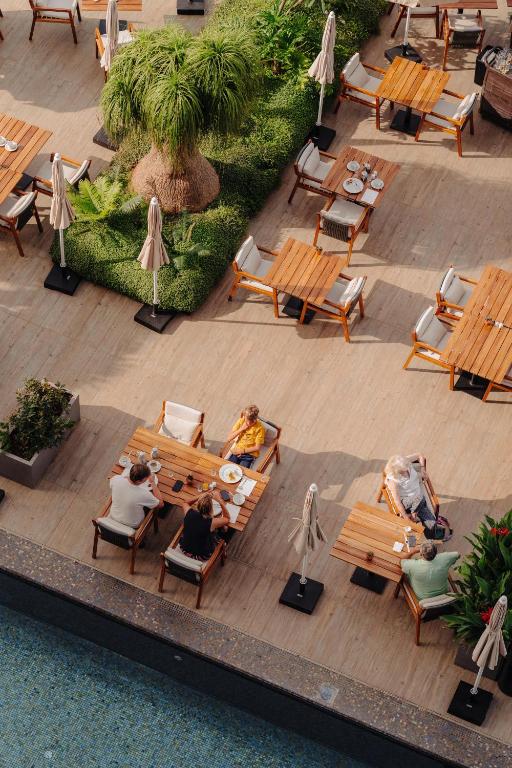 a group of people sitting on benches in a courtyard at Saccharum - Resort and Spa - Savoy Signature in Calheta