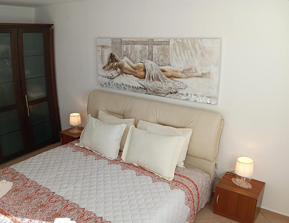 una camera da letto con un letto e un dipinto sul muro di Serenity Apt Iztok Sofia a Sofia