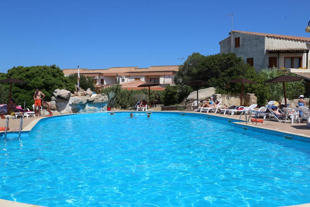 a large blue swimming pool with a water slide at Club Esse Residence Capo D'orso in Palau