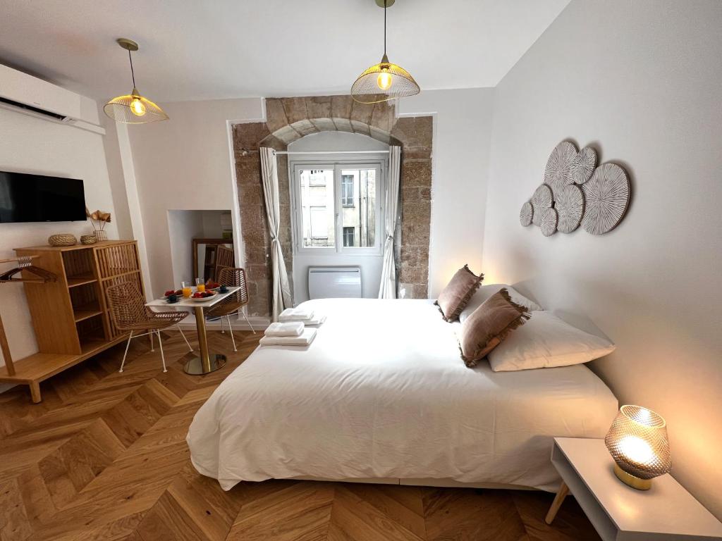une chambre avec un grand lit blanc et une table dans l'établissement Le Comte - Heart of Dijon - With AC, à Dijon