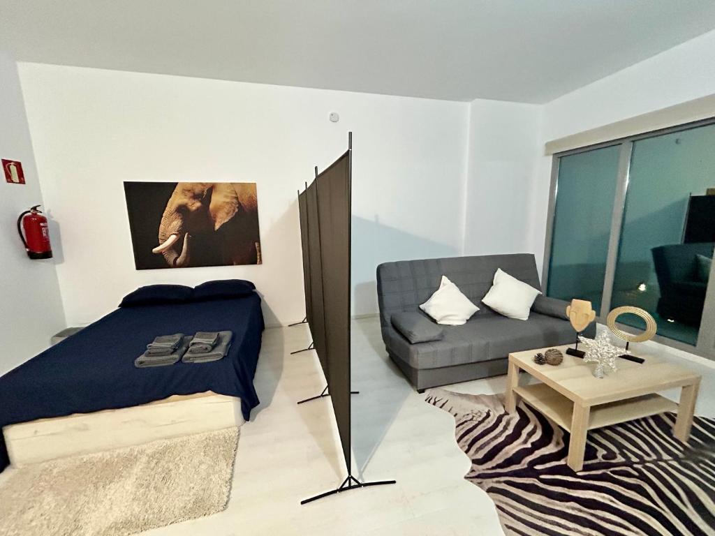a bedroom with a bed and a couch at De Madrid al cielo suites con wifi y Netflix in Madrid