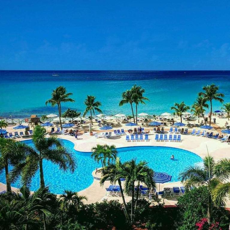 a view of a resort with a pool and the ocean at Royal Islander Club Resort La Plage in Lowlands