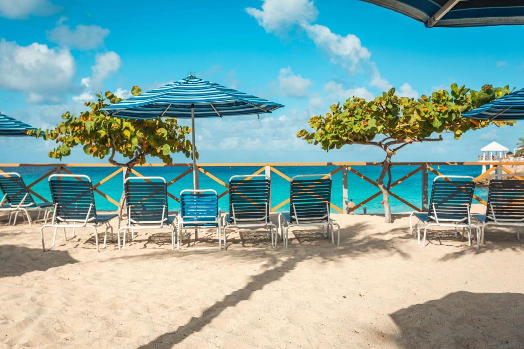 a group of chairs and umbrellas on a beach at Royal Islander Club Resort La Plage in Lowlands