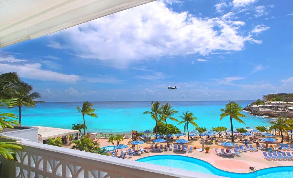 a view of the beach and the ocean from the balcony of a resort at Royal Islander Club Resort La Plage in Lowlands