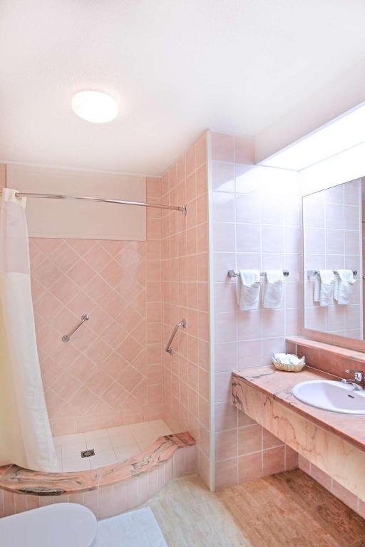 a bathroom with a shower and a sink at Royal Islander Club Resort La Plage in Lowlands
