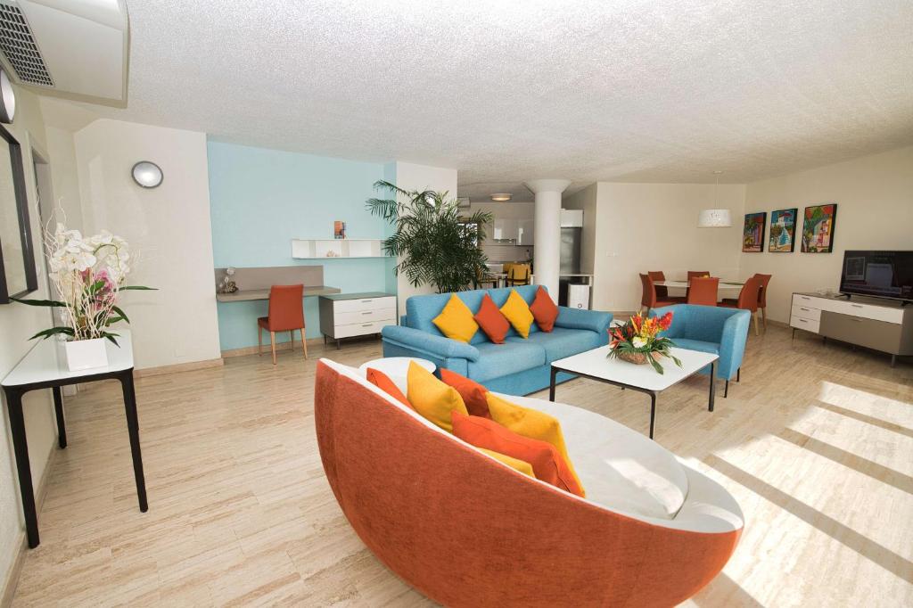 a living room with a couch and a table at Royal Islander Club Resort La Plage in Lowlands