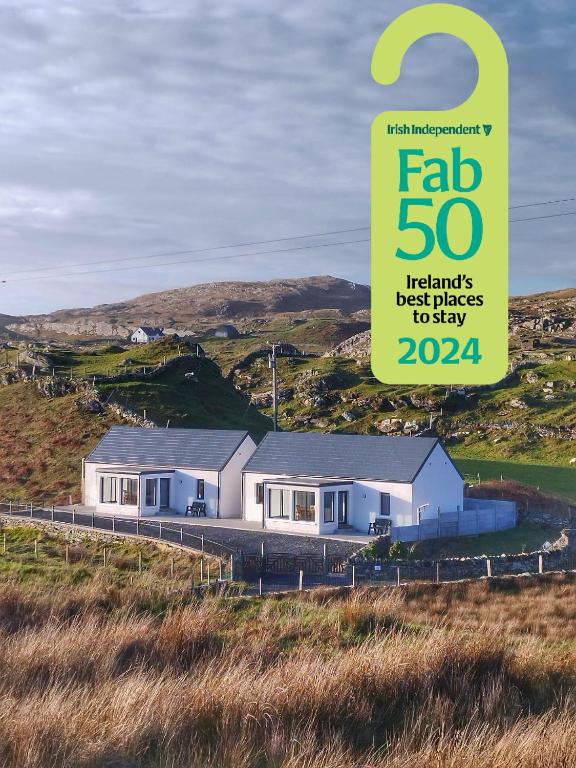 a house on a hill with a sign that reads fab luxury residence packages at Craggy Cottage 1 in Inishturk