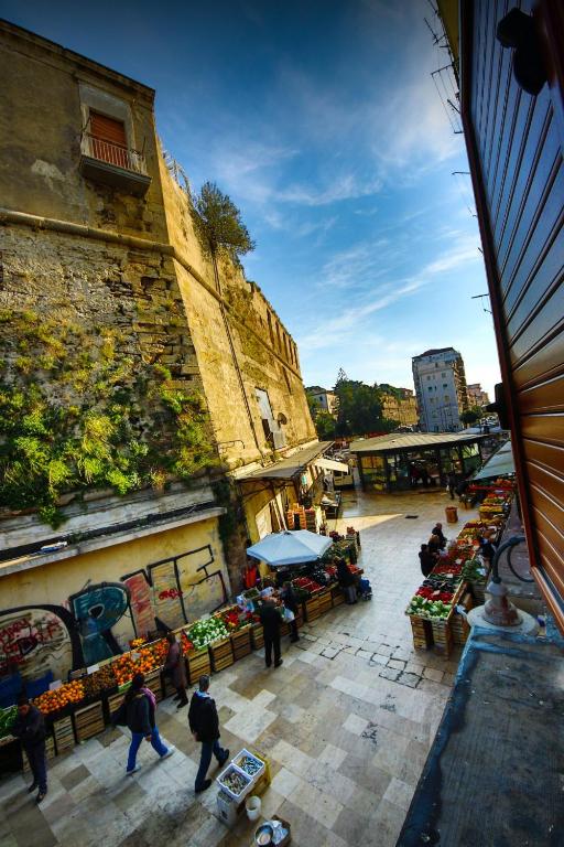 a group of people walking around an outdoor market at La Corte del Geco in Crotone