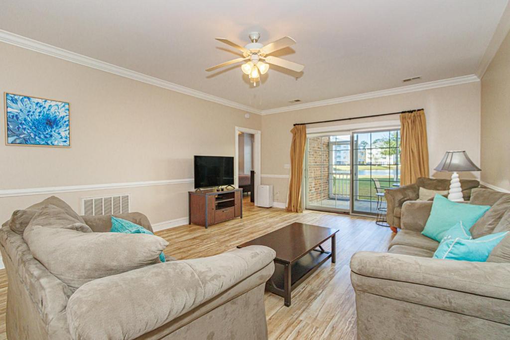a living room with two couches and a table at Ground Floor 3 Bedroom Condo! Magnolia Pointe 105! Sleeps 6 guests in Myrtle Beach