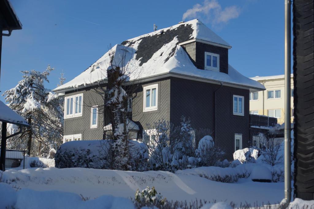 ein Haus mit einem schneebedeckten Dach in der Unterkunft Apartment Johanna Oberhof in Oberhof