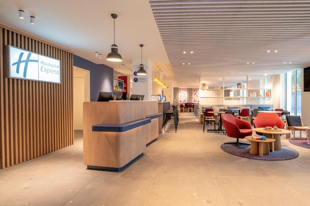 a lobby with a bar and tables and chairs at Holiday Inn Express & Suites Ghent by IHG in Ghent