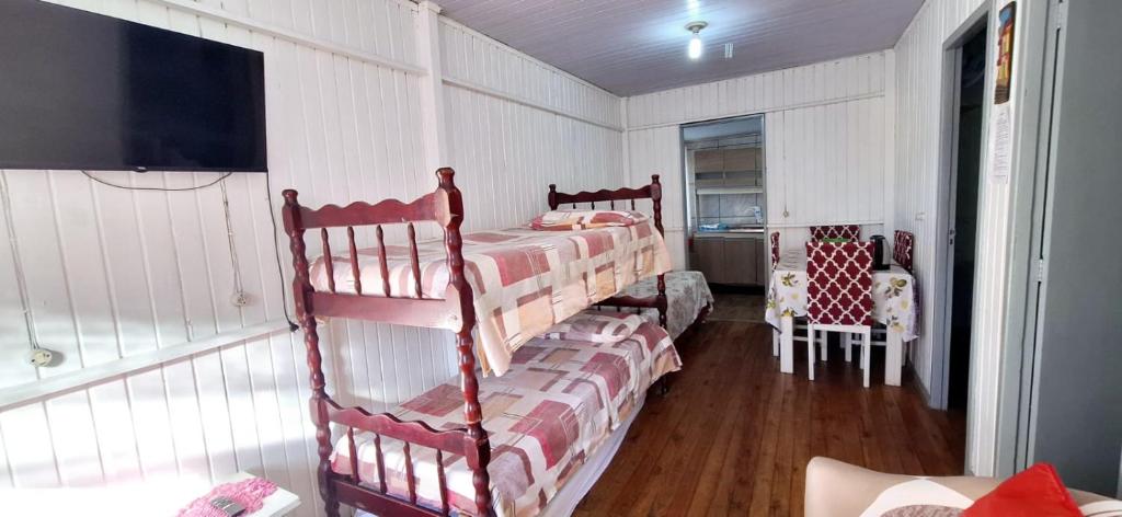 a bedroom with two bunk beds in a room at CASA de 2 quartos com 2 ares-condicionados em TORRES-RS - Na mais bela praia Gaúcha - Cozinha - Banheiro - TV smart 32 e Wi-Fi - Estacionamento - Anfitriã Superhost no BnB in Torres