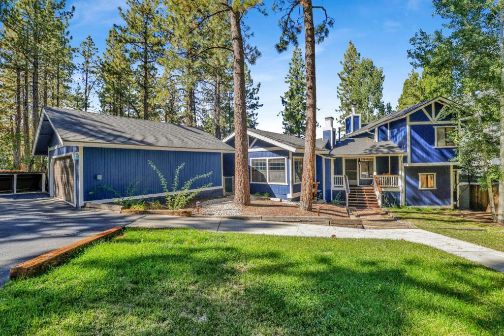 a blue house with a yard and trees at Serenity Cove Lake House #2472 by Big Bear Vacations in Big Bear Lake