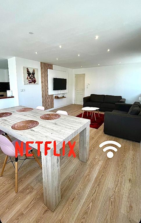 un salon avec une table et un canapé dans l'établissement Grande chambre dans loft à deux pas de la plage, à Dunkerque
