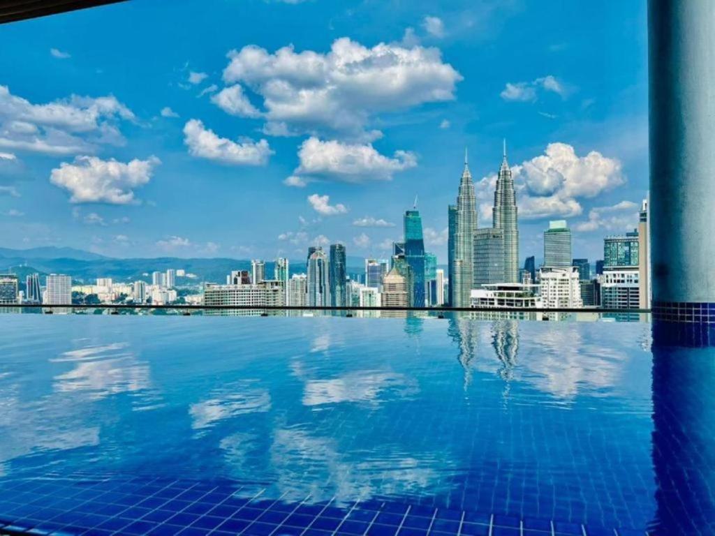 a view of a city skyline from a swimming pool at The Luxe Colony KLCC by Sky Pool in Kuala Lumpur