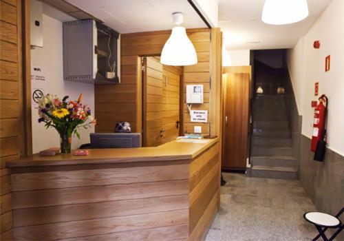 a lobby with a reception desk with a vase of flowers at Pensión San Fermín in San Sebastián