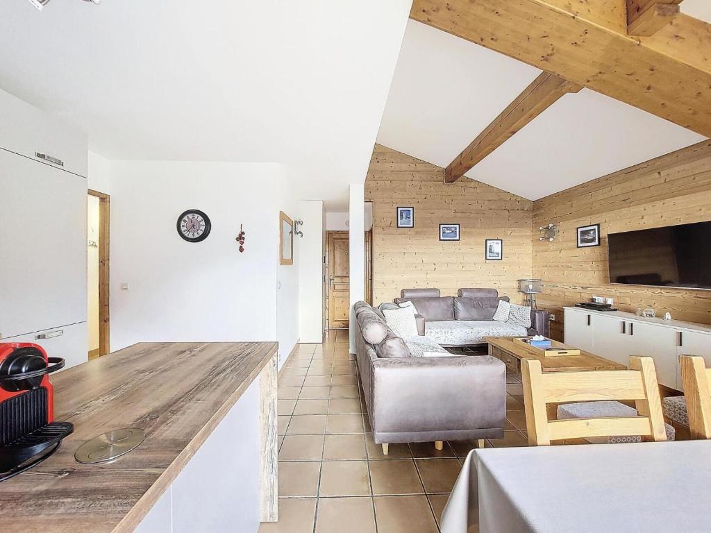 una cucina e un soggiorno con divani e tavolo di Le Chalet Des Eucherts - Appartement de 6 pièces de 110 m2 pour 10 personne MAE-3194 a Montvalezan