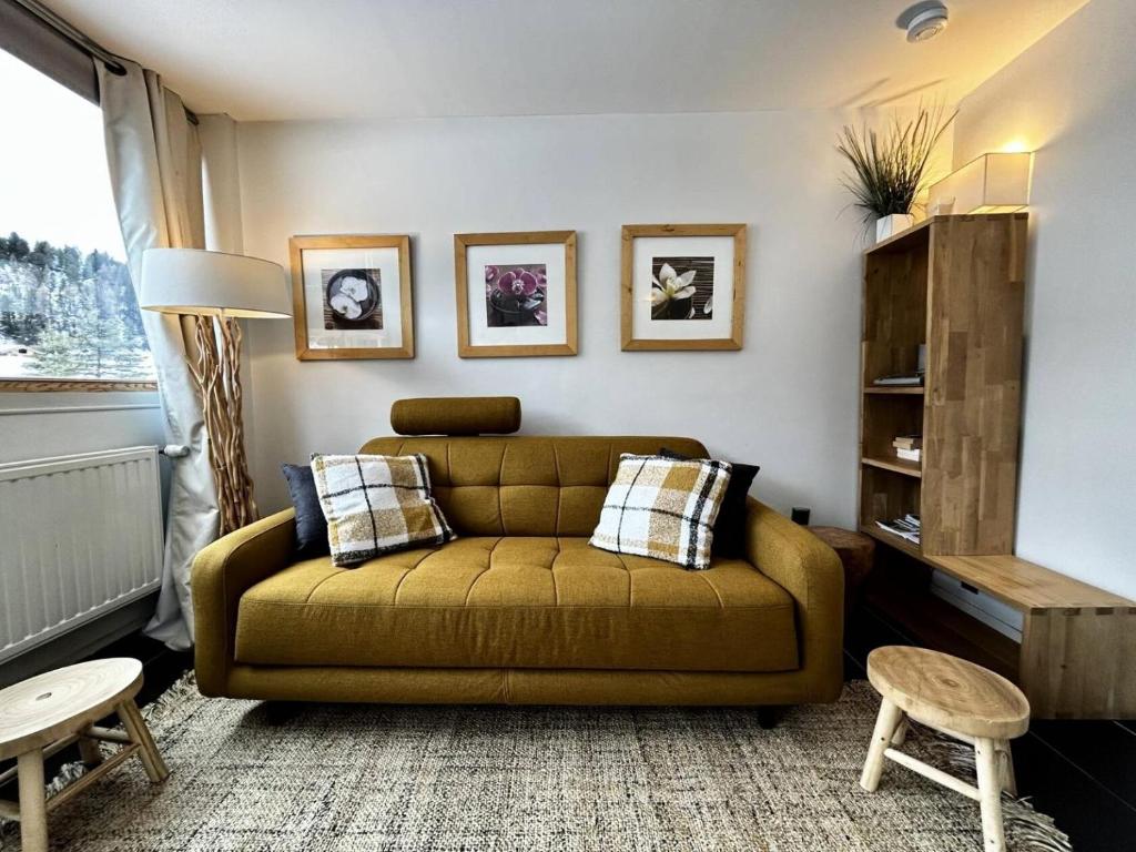 un salon avec un canapé vert et une fenêtre dans l'établissement Résidence Le Pelvoux - Résidence PELVOUX N°120 MAE-1471, à La Plagne Tarentaise