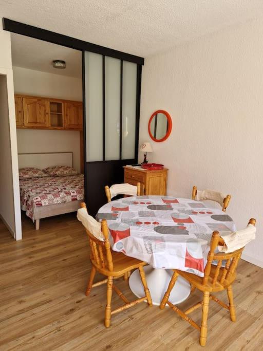 une pièce avec une table et deux chaises et un lit dans l'établissement Appartement aux pieds des pistes - Apollo Le Corbier, à Villarembert