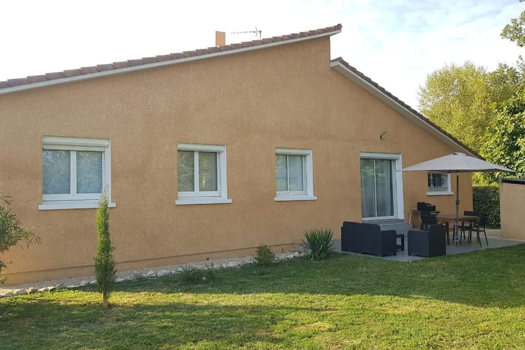 une maison avec une table et un parasol dans l'établissement Maison, à Lombez
