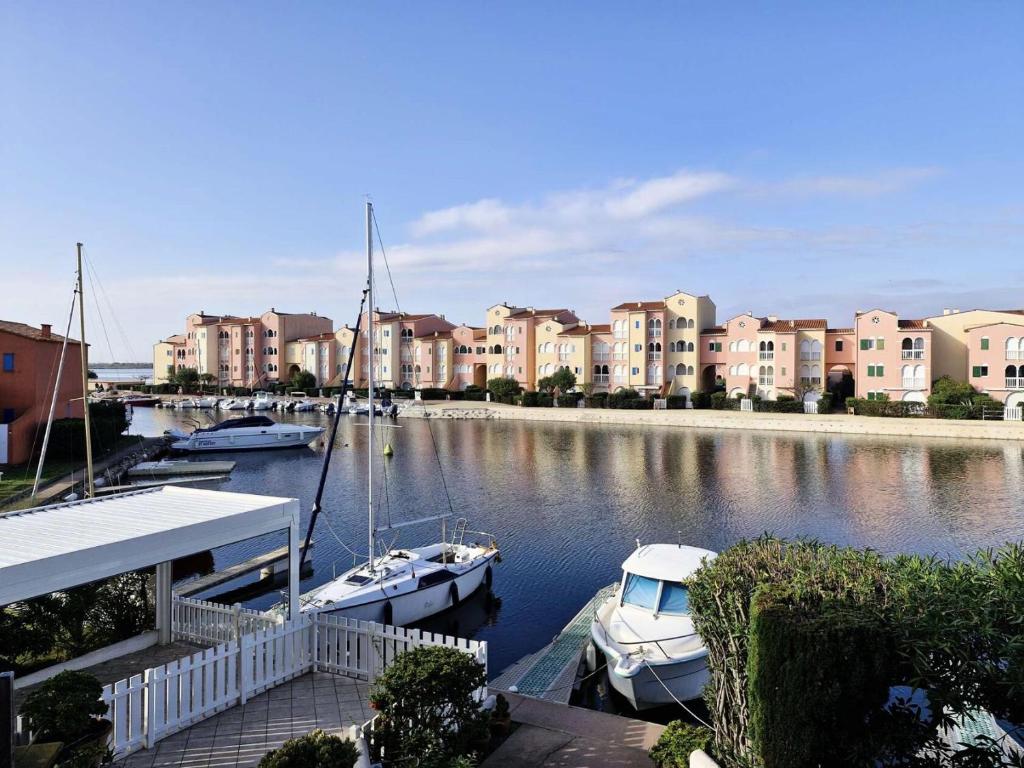 Quelques bateaux amarrés dans un port de plaisance avec des bâtiments dans l'établissement Résidence Nautica - Studio 3 personnes LE BARCARES. Réf: 9NAU11_23 MAE-9341, au Barcarès