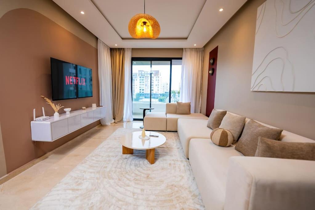 una sala de estar con un sofá y una mesa en Prestigia Gem Spacious 3BR Flat in Hay Riad, en Rabat