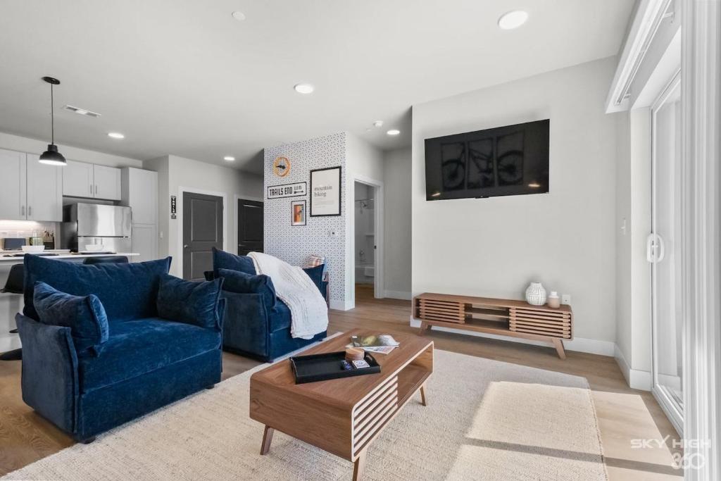 a living room with two blue couches and a table at Trails End Here, Pool, King Beds, Gym, Lux Apt in Rogers