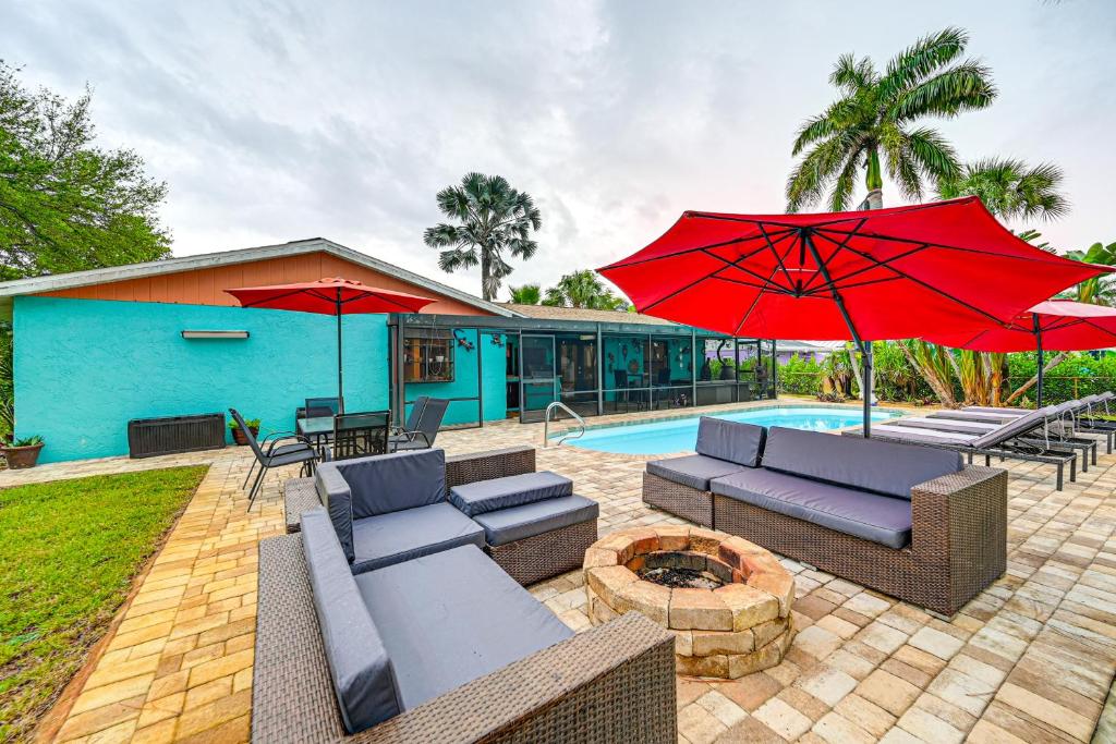 a patio with couches and umbrellas next to a pool at 4 Mi to Beach Pet-Friendly Home in Naples! in Naples