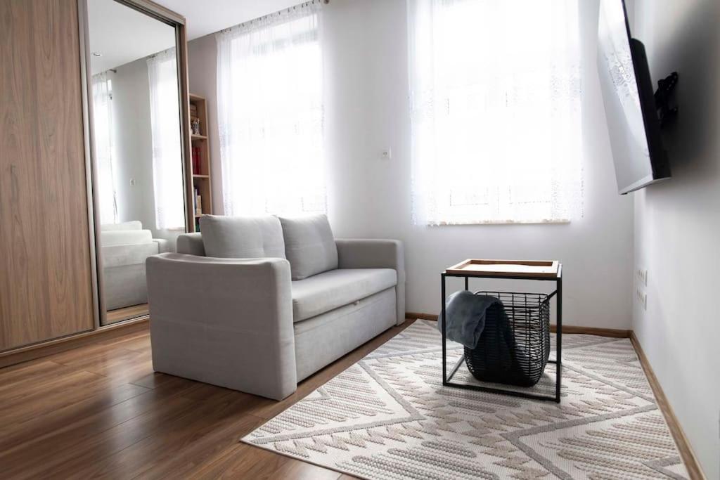 a living room with a white couch and a table at Apartament pod Katedra w Gnieznie in Gniezno