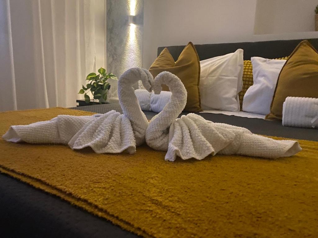 Dos cisnes de toalla sentados encima de una cama en Hastoci House, en Lido di Ostia
