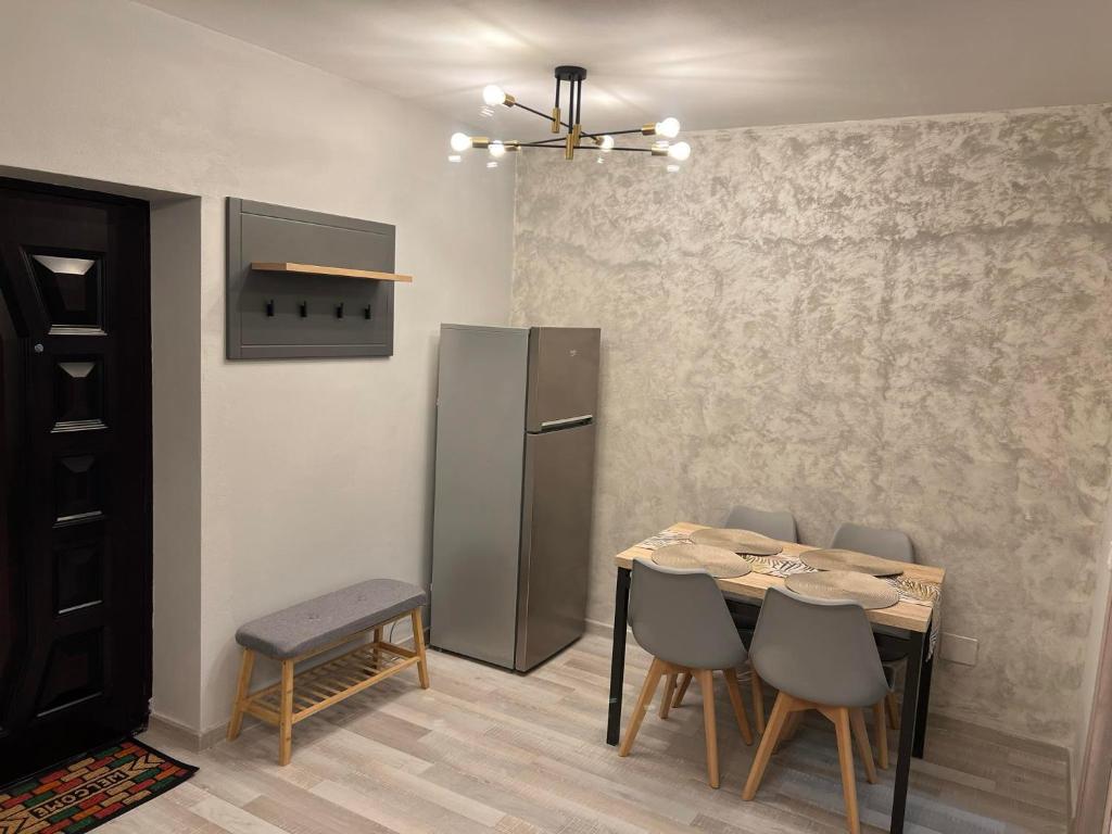 a kitchen with a table and a refrigerator at Apartament Marieva 1 in Craiova