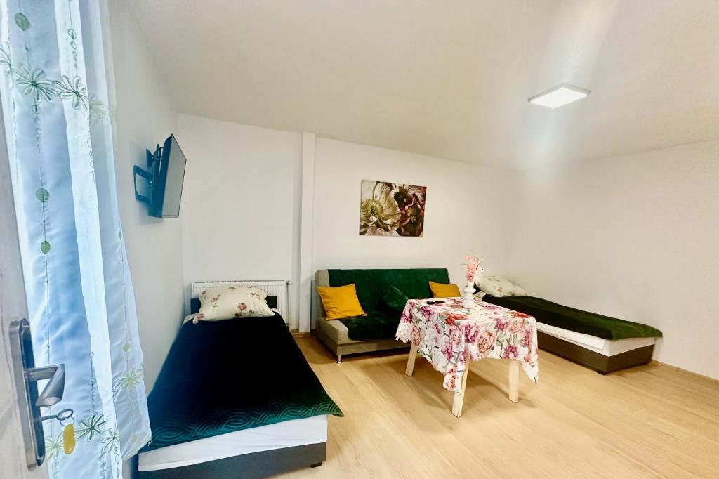 ein Wohnzimmer mit Sofa und Tisch in der Unterkunft Apartament nr 1 lub 2 przy Sali Kominkowej in Przeczyce