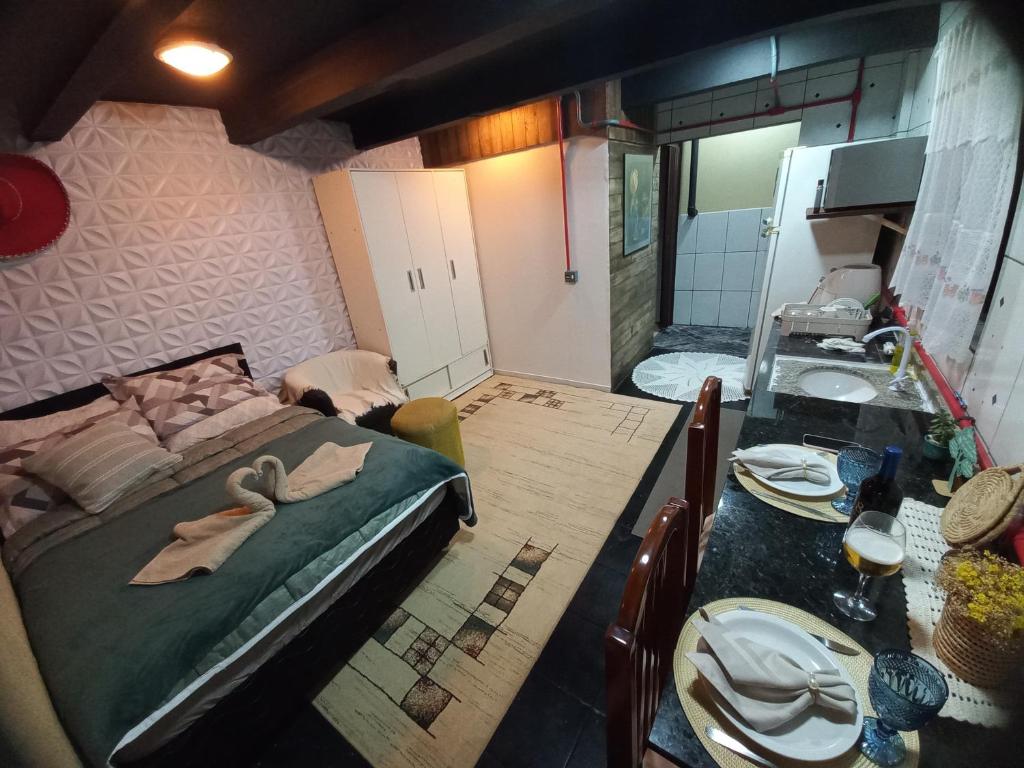 Un dormitorio con una cama y una mesa con platos. en Apartamento, Suíte com cozinha, en Penha