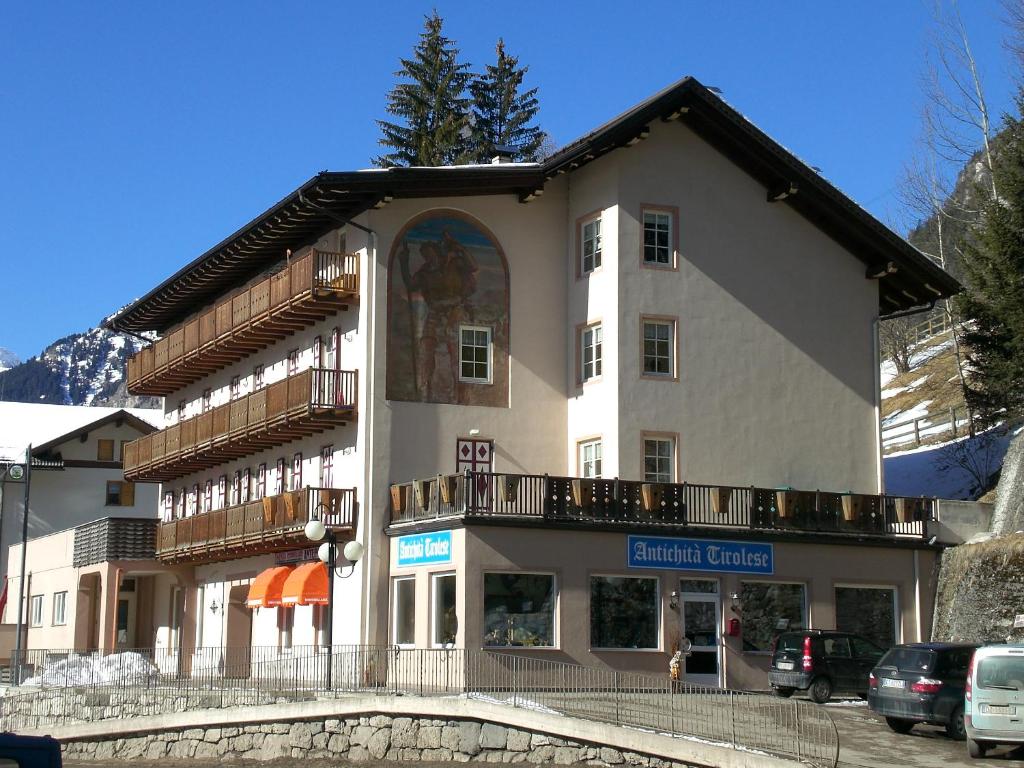 a large white building with a balcony on a street at San Cristoforo in Canazei