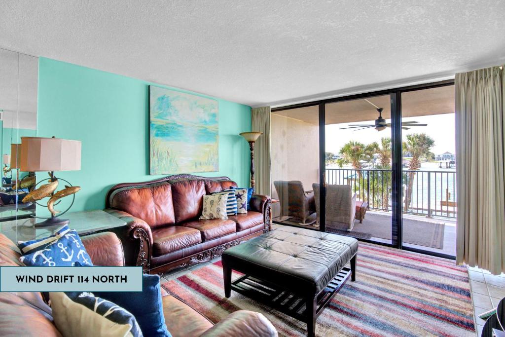 a living room with a leather couch and a table at Wind Drift 114 North by Vacation Homes Collection in Orange Beach