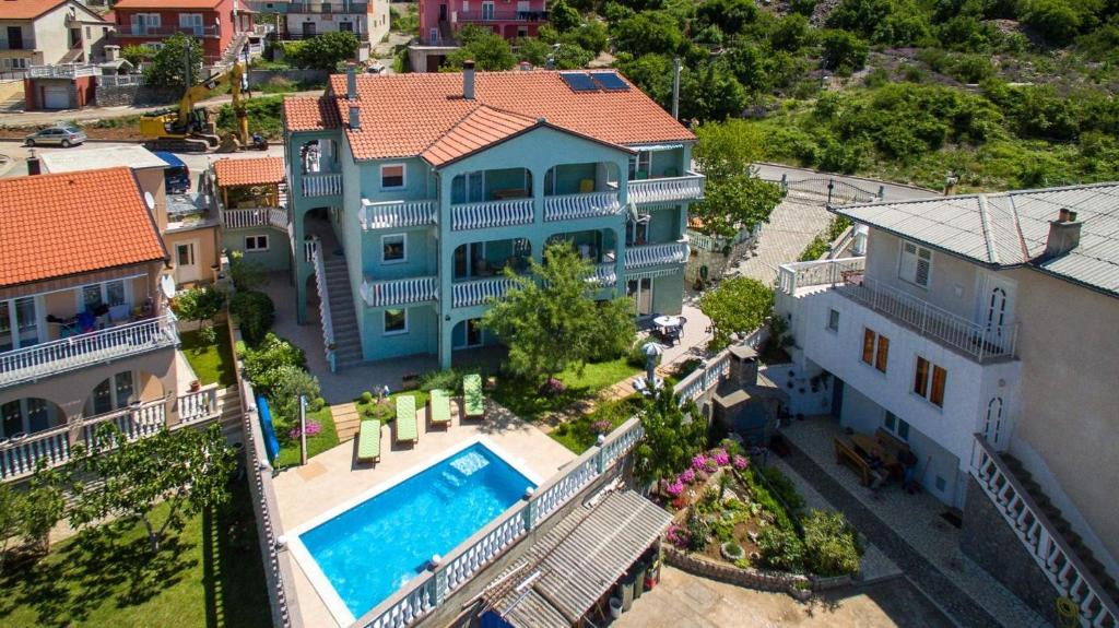 an aerial view of a large blue house with a swimming pool at Apartments and rooms with a swimming pool Senj - 23592 in Senj