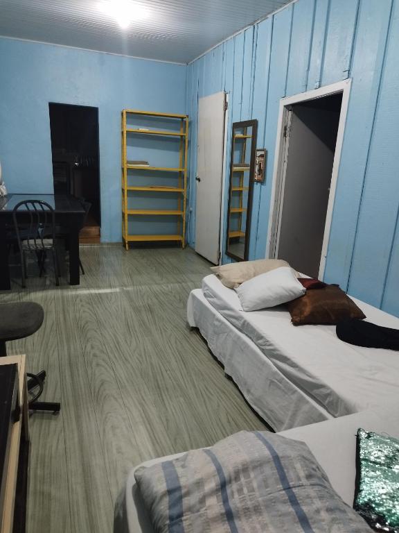 a room with two beds and a piano in it at Casa central 349 in Ponta Grossa