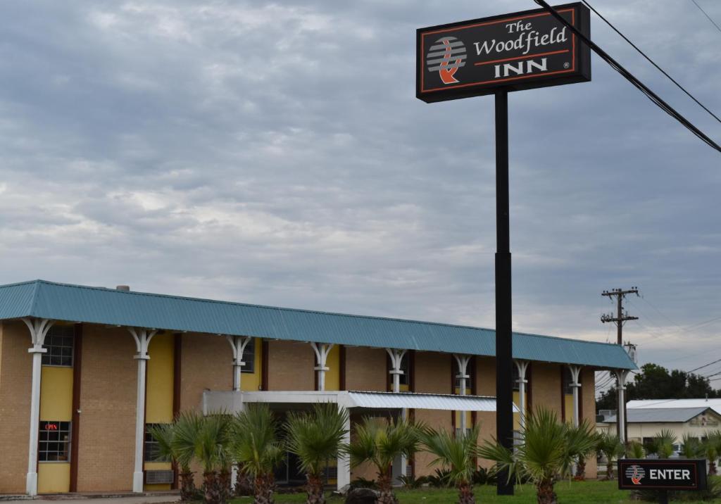 a building with a sign in front of it at Woodfield Inn and Suites in Yoakum