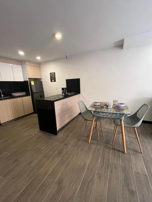 een kamer met een tafel en stoelen en een keuken bij Spacio 202 in Cali