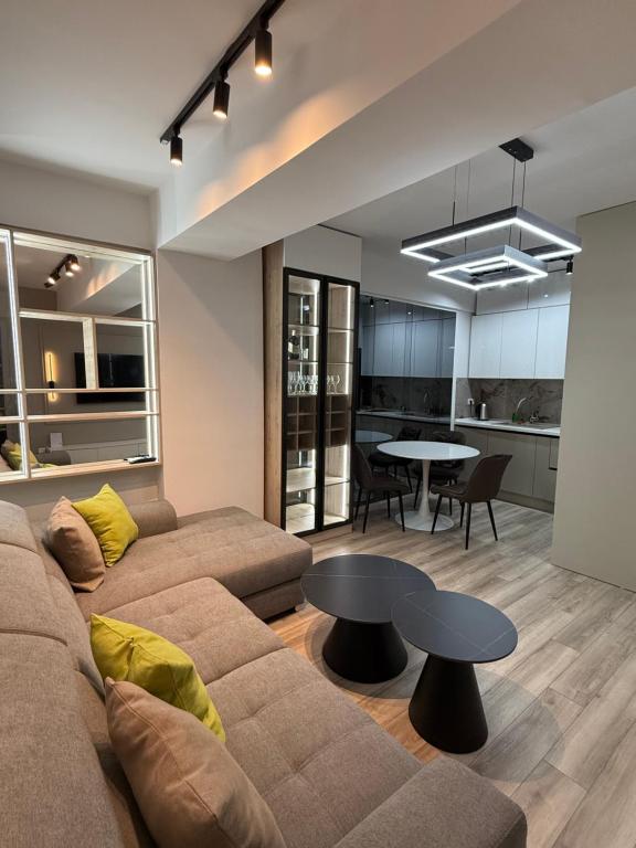 una sala de estar con un sofá y una mesa en New Modern One bedroom Apartment Julija, en Skopje