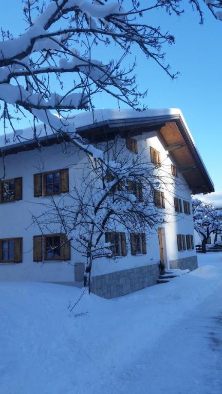 un edificio con nieve en el suelo delante de él en Ferienhof Leo, en Steeg