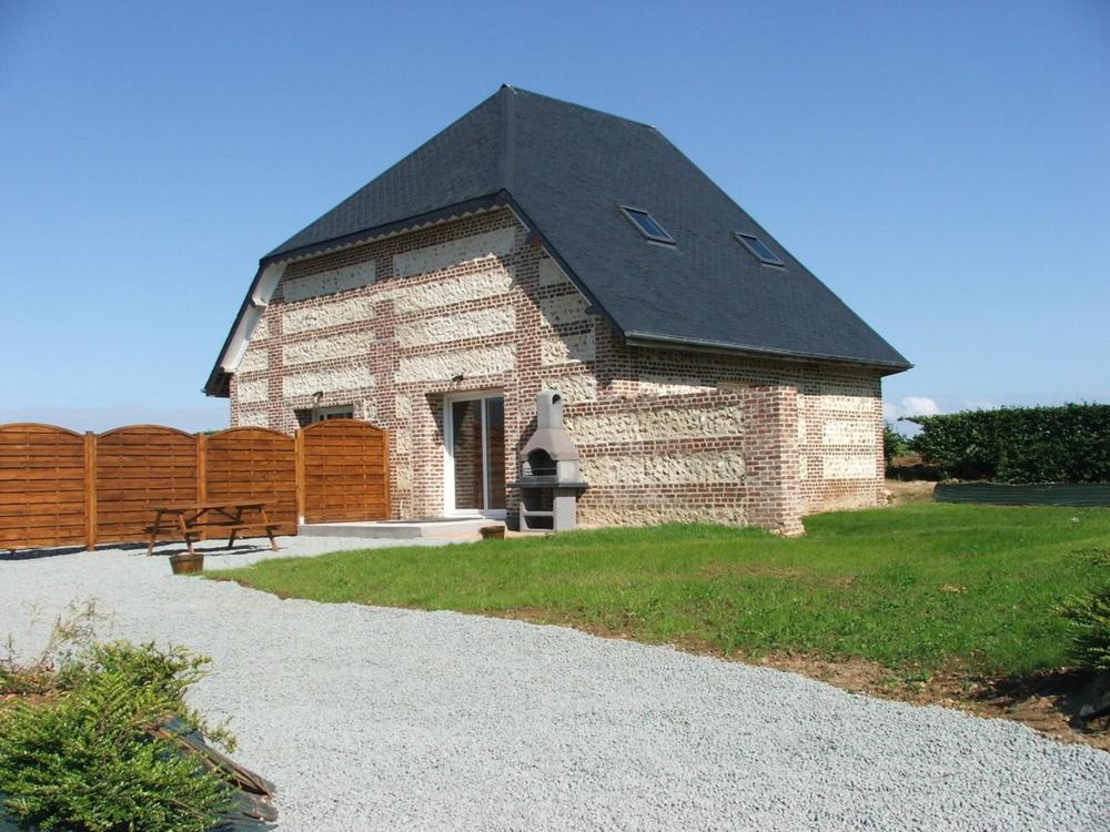 a small brick building with a black roof at Les Champs De La Mer in Auberville-la-Renault