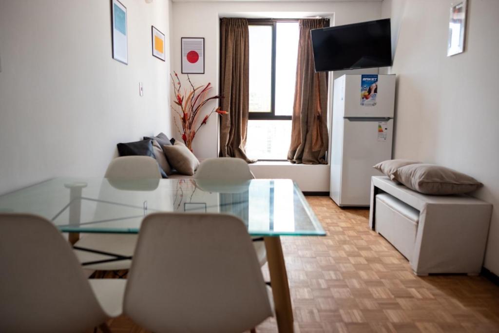 a living room with a glass table and chairs at El diez 1 dorm con COCHERA in Córdoba