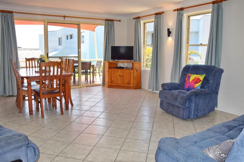 a living room with a couch and a table and chairs at Ocean Shores 7 South West Rocks - Bring you own linen. in South West Rocks