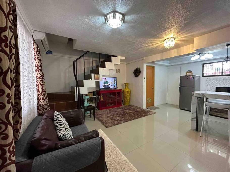 a living room with a couch and a dining room at Conveniently 3 Bedroom Cozy Cozy Corner Townhouse Near Robinson Mall, Butuan Doctors Hospital and Airport in Butuan