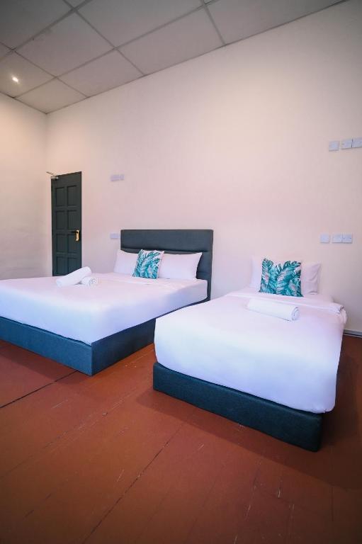 2 letti posti uno accanto all'altro in una stanza di Swing & Pillows - 75 Chulia St, Georgetown Penang a George Town