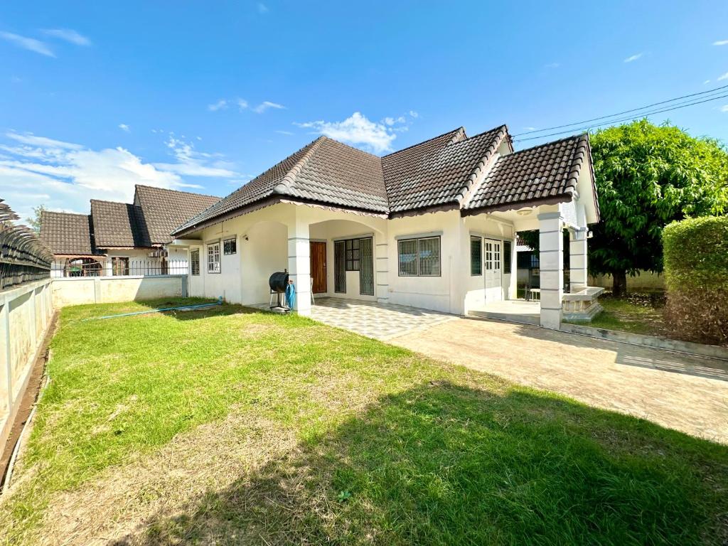 a large white house with a yard at Cozy 3 BR house & green lawn near Airport & Old town in Chiang Mai