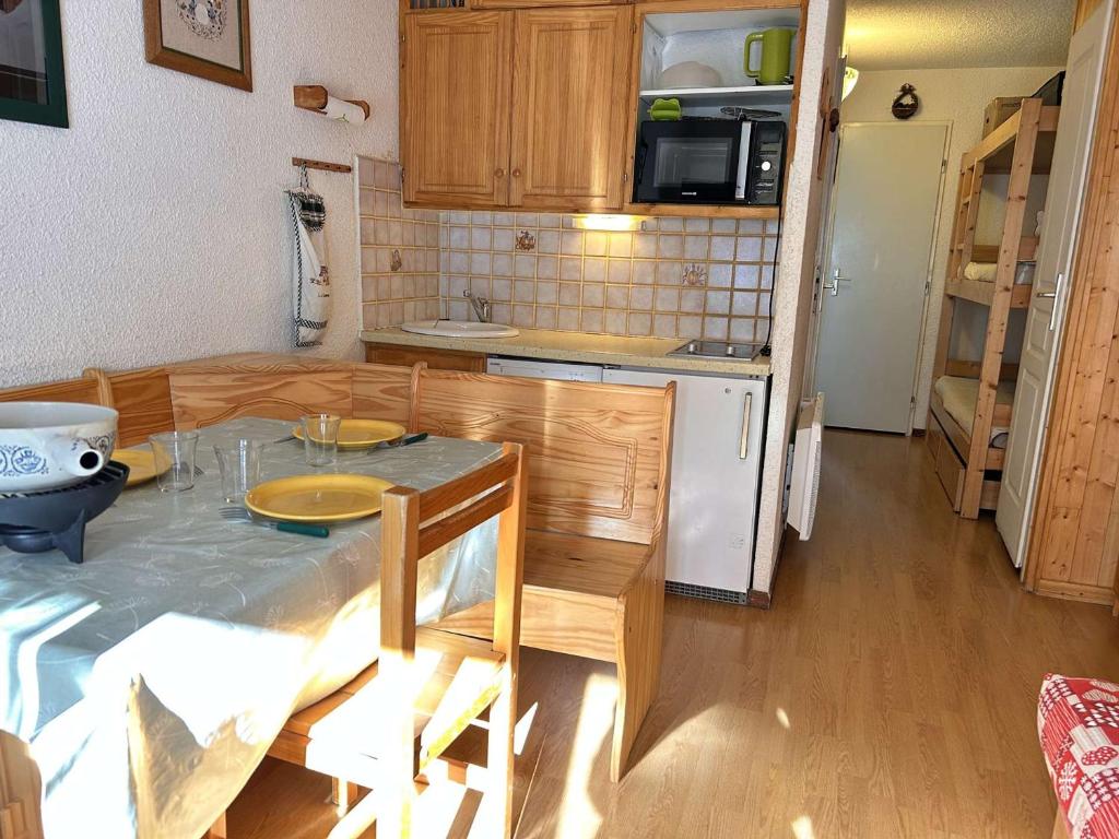 une petite cuisine avec une table et un réfrigérateur dans l'établissement Studio à Risoul 1850, 4 couchages, proche pistes - FR-1-330-584, à Risoul